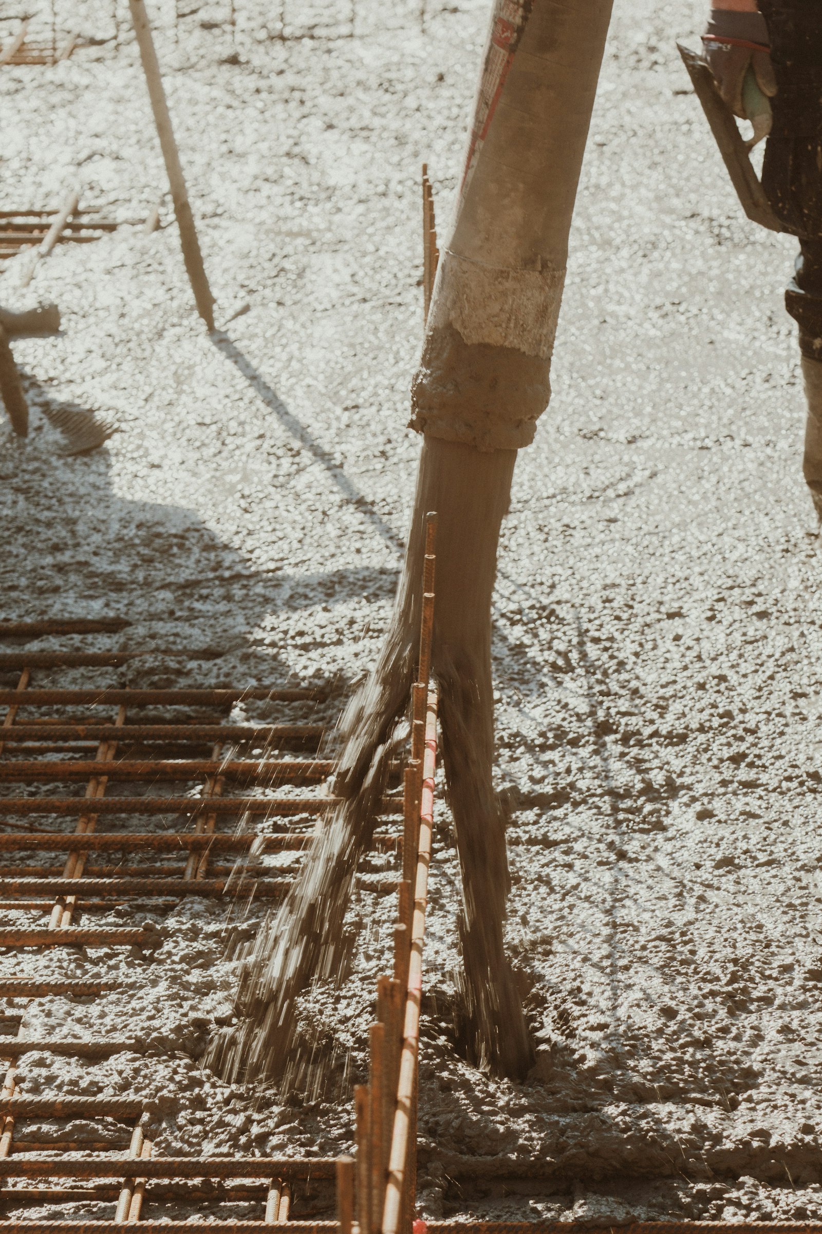 Concrete being poured across reinforcing steel